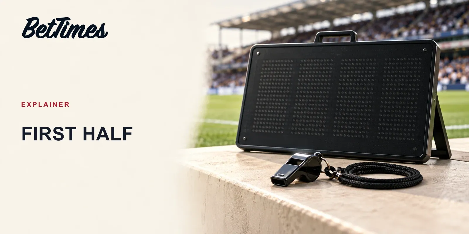 A referee's whistle rests beside an unlit added-time board near a football touchline, illustrating the first-half boundary.